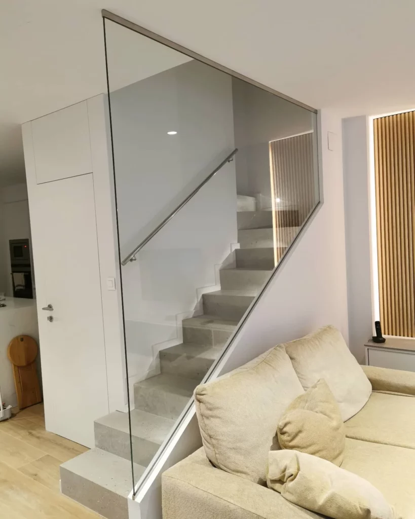 Panel de vidrio a medida como baranda de escalera interior con pasamanos metálico